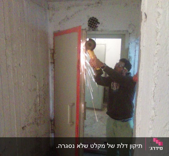 אדם משתמש בכלי חיתוך על דלת